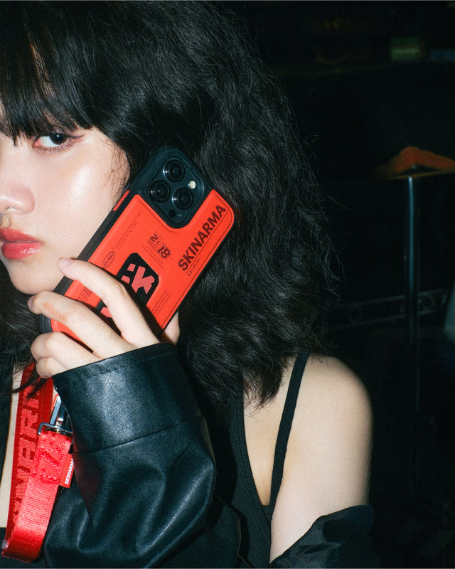 A woman with black hair holding a red phone case